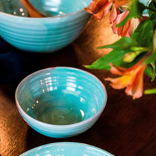 Load image into Gallery viewer, Small turquoise bowl with a large bowl in the background sitting on a dark wooden table.