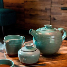 Load image into Gallery viewer, Turquoise mik jug, sugar bowl, teapot sitting on a wooden table.