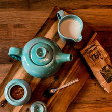 Load image into Gallery viewer, Turquoise Teapot, milk jug and sugar bowl from above on a wooden board.