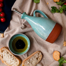 Load image into Gallery viewer, Turquoise oil pourer on it&#39;s side beside a small turquoise bowl with oil and balsamic vinegar on a cream tablecloth.
