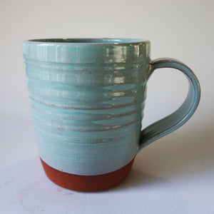 Turquoise mug on a back round