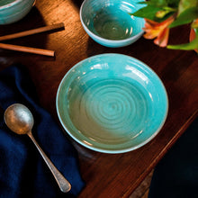 Load image into Gallery viewer, Turquoise pasta bowl on a dark table with navy napkin and soup spoon.
