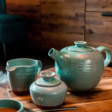 Load image into Gallery viewer, Turquoise mik jug, sugar bowl, teapot sitting on a wooden table.
