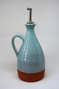 Turuoise oilbottle with a metaltop on a white background