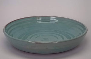 Turquoise shallow pasta bowl on a white background